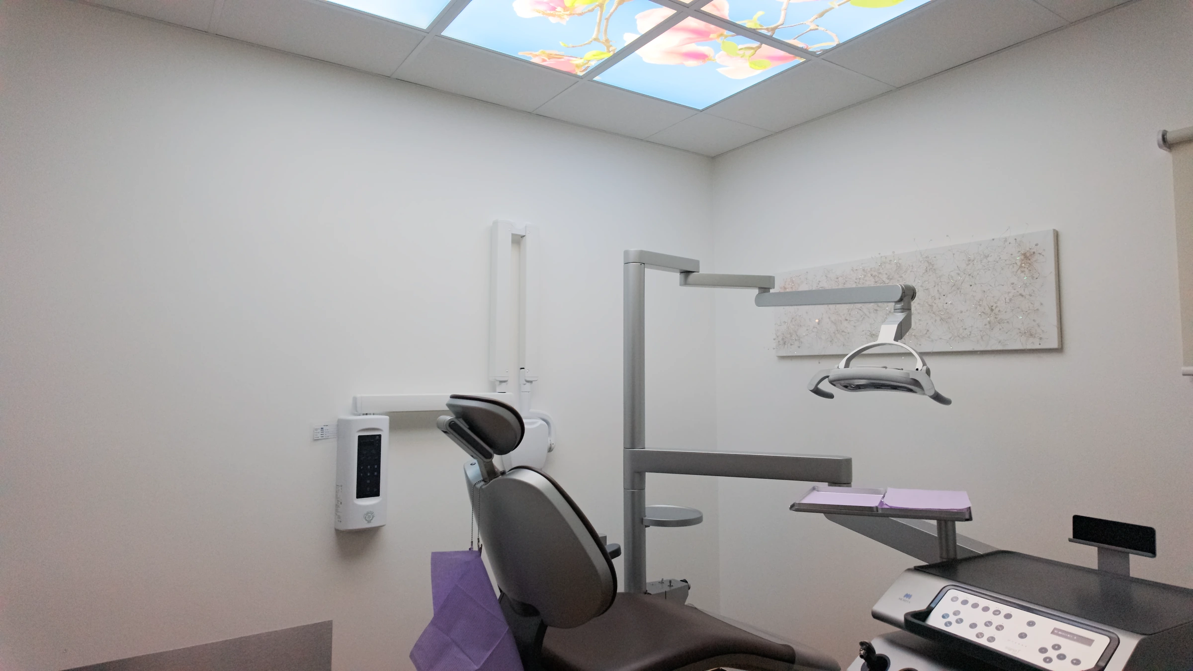 Behandlungszimmer mit Behandlungsstuhl und beleuchteter Motivdecke